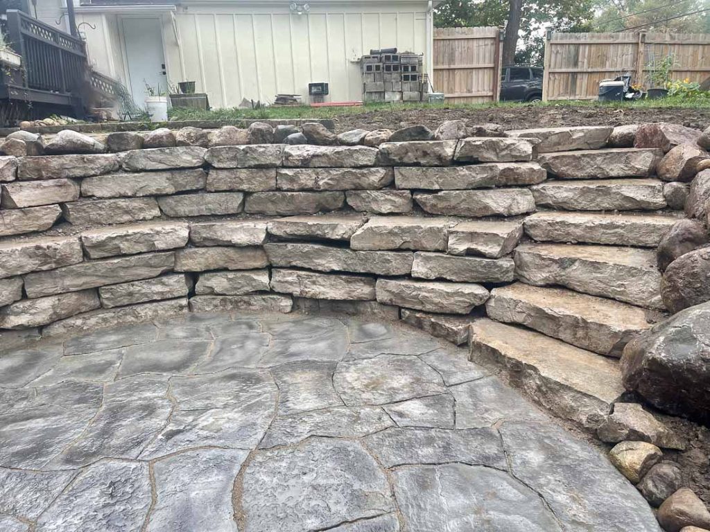 masonry upgrades, a patio and stacked stone retaining wall