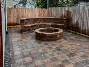 Rustic brick paver patio with built-in fire pit and sitting area. 